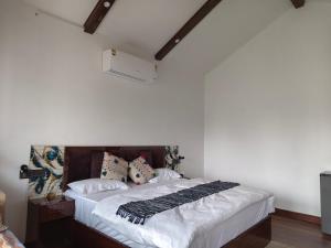 una camera da letto con un letto con lenzuola e cuscini bianchi di The Tiger Waterfront Resort a Mādho Tānda