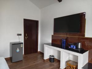 The Tiger Waterfront Resort في Mādho Tānda: غرفة معيشة مع تلفزيون ومكتب مع تلفزيون