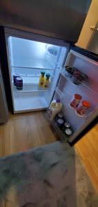 an empty refrigerator with its door open in a kitchen at Borealis Bungalow and Hot Tub in Fairbanks