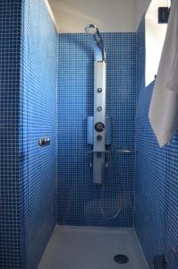 y baño de azulejos azules con ducha y lavamanos. en Anny's Homes, en Kountoura Selino