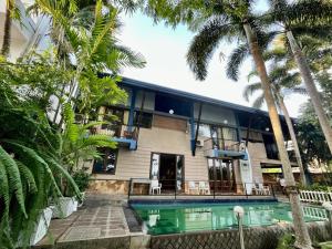 una casa con piscina y palmeras en Bolgoda Lake Bungalow, en Panadura