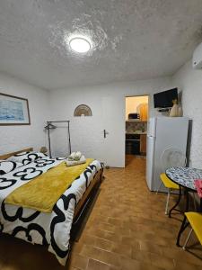 a bedroom with a bed and a refrigerator and a table at Cocody in Lumio