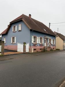 a blue house on the side of a street at Gîte au secret des vignes in Bergholtz