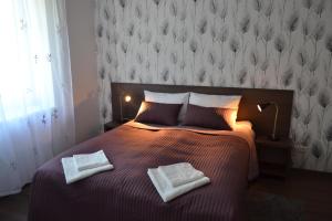 a bedroom with a bed with two towels on it at NG Apartments in Plungė