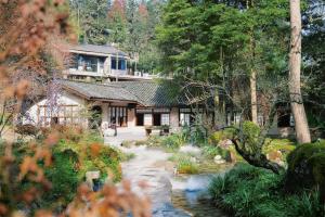 ein Haus mit einem Bach vor einem Garten in der Unterkunft Relais & Châteaux Su Shien Valley Hotel in Dujiangyan