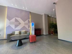 Borrman Hotel Korla Peacock River في كورلا: لوبي فيه كنب وطاولة في الغرفة