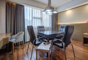 a dining room with a table and chairs at Borrman Hotel Nanning Anji Passenger Station Xijin Metro Station in Nanning