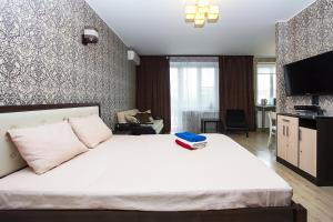 a bedroom with a large white bed and a tv at ApartLux 1905 goda Suite in Moscow