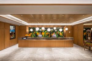 a lobby of a hotel with a reception counter at Orange Nanjing Baijia Lake Xiaolongwan Subway Station Hotel in Jiangning
