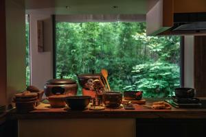 eine Küchentheke mit Töpfen und Tassen und ein Fenster in der Unterkunft Relais & Châteaux Su Shien Valley Hotel in Dujiangyan