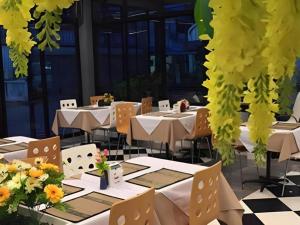 a restaurant with tables and chairs with flowers on them at The Grace Residence in Surin