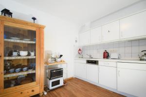 a kitchen with white cabinets and a counter top at Fewo Jule in Norderney