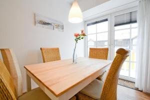 a dining room table with chairs and a vase with flowers at Fewo Jule in Norderney