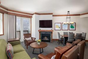a living room with a couch and a fireplace at The Lodge at Spruce Peak, a Destination by Hyatt Residence in Stowe
