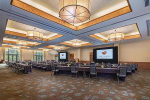 a conference room with tables and chairs and a screen at The Lodge at Spruce Peak, a Destination by Hyatt Residence in Stowe +166 photos