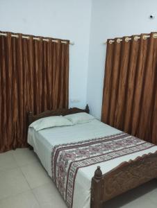a bedroom with a bed with a canopy and curtains at Sankeerthanam - Lounge in serenity in Cochin