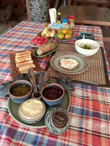 ein Tisch mit Tellern voller Essen auf einer karierten Tischdecke in der Unterkunft ออร์คิดไฮบิสคัส เกสท์เฮ้าส์ in Sukhothai + 14 Fotos