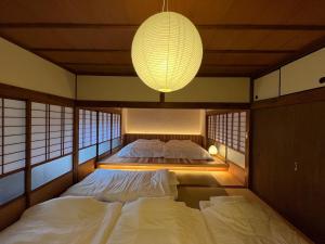 a bedroom with two beds and a chandelier at Newopen 一棟貸切宿YUNOWA 車3台駐車可 6名様まで同料金 in Nagato