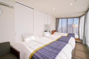 岡山市にあるスリーウエルネスのベッドが2つと大きな窓がある寝室 +62枚の写真