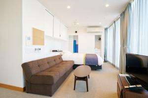 岡山市にあるスリーウエルネスのソファとベッドのあるリビングルーム