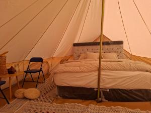 Un dormitorio con una cama en una tienda de campaña. en ESCAPE cAMp, en Badīyah 28 fotos más