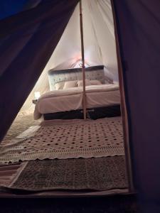 1 cama dentro de una tienda de campaña con colchón en ESCAPE cAMp, en Badīyah
