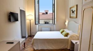 ein kleines Schlafzimmer mit einem Bett und einem Fenster in der Unterkunft Il Dromedario in Florenz