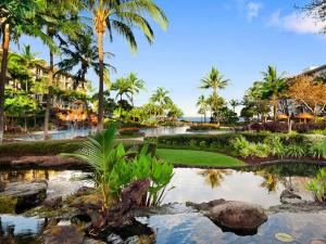a golf course with palm trees and a pond at The Westin Kāʻanapali Ocean Resort Villas-Ocean Front STUDIO VILLA in Lahaina