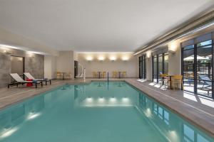 una piscina en un hotel con mesas y sillas en Home2 Suites By Hilton Flagstaff, en Flagstaff