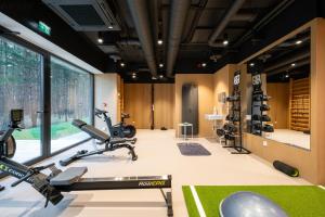 un gimnasio con cintas de correr y máquinas elípticas en Studio apartment with gym, parking, coworking, en Maardu