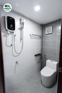 ein Bad mit Dusche und WC sowie einen TV in der Unterkunft OMEGA HOUSE Thốt Nốt in Thốt Nốt + 35 Fotos