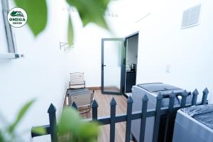 ein Balkon mit Glastür und Zaun in der Unterkunft OMEGA HOUSE Thốt Nốt in Thốt Nốt