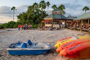 a group of boats on a beach with a group of people at Sunset Suite - Private Balcony Gym & Pool in Ruskin
