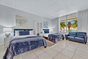 a bedroom with a bed and a chair and a window at Sunset Suite - Private Balcony Gym & Pool in Ruskin +46 photos