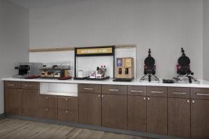 Hampton Inn & Suites By Hilton Wheat Ridge Denver West في ويت ريدج: مطبخ مع خزائن خشبية وطاولة عمل