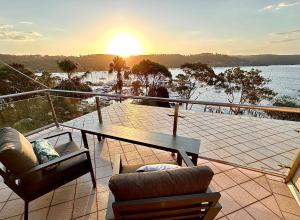 a balcony with a table and chairs and a view of the water at BlueWater Penthouse GuestSuite 2 in Newport