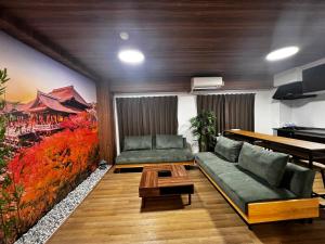 uma sala de estar com um sofá e uma mesa em Zen Stay Benten 6guests Easy access to Umeda Shinsaibashi USJ em Wada