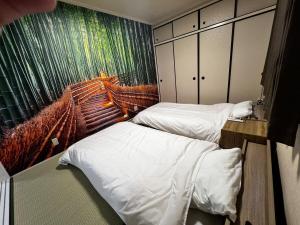 duas camas em um quarto com uma pintura na parede em Zen Stay Benten 6guests Easy access to Umeda Shinsaibashi USJ em Wada
