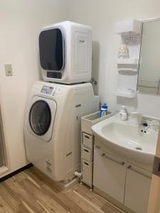 uma máquina de lavar com uma TV em cima em um banheiro em Zen Stay Benten 6guests Easy access to Umeda Shinsaibashi USJ em Wada