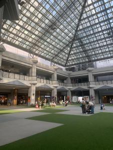 um grande edifício com teto de vidro e grama verde em Zen Stay Benten 6guests Easy access to Umeda Shinsaibashi USJ em Wada