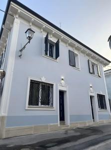 een wit gebouw met zwarte ramen en een straat bij Casa Magenta Apartments in Valeggio sul Mincio