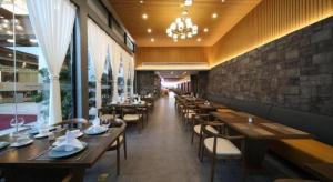 Un restaurante con mesas y sillas de madera en una sala. en Xiamen Seashine Lakeview Hotel, en Xiamen