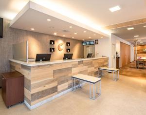 a lobby with a counter with laptops on it at Comfort Hotel Saga in Saga