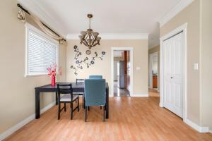 a dining room with a table and chairs and a chandelier at Cozy Stay in Metrotown Steps to SkyTrain in Burnaby