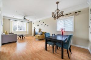 a living room with a dining room table and chairs at Cozy Stay in Metrotown Steps to SkyTrain in Burnaby +17 photos
