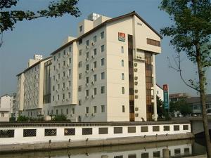 a large building next to a body of water at Jinjiang Inn Shaoxing Shengli West Road Luxun Hometown in Shaoxing
