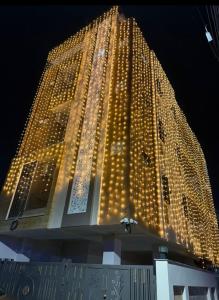 Un grand bâtiment avec des lumières allumées la nuit dans l'établissement Madhav Villa, à Jaipur