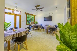 ein Esszimmer mit Tischen, Stühlen und Pflanzen in der Unterkunft Ameera Maldives in Dhiffushi