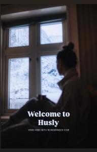 a woman looking out a window with the words welcome to hugs at Husly Reine - your home with Reinebringen view in Reine