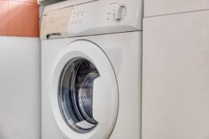 eine weiße Waschmaschine in einer Waschküche in der Unterkunft Sienna Velvet Room - Balneo & Cinema - Ligne 9 in Montreuil